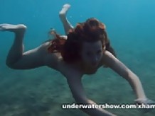 Julia is swimming underwater nude in the sea