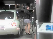 Short skirt girl putting gas in car