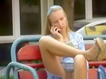 Girl seating in a bench shaved pussy upskirt