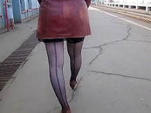 Girl in seamed stockings walking on a train station