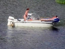 Pareja nudista se divierte en el medio de un hermoso lago