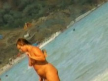 Escenas de playa nudista con amateurs bañándose en el mar.