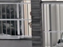 El vecino desnudo sexy se queda frente a la ventana abierta