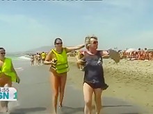 Los nudistas españoles maduros caminan por la playa completamente desnudo