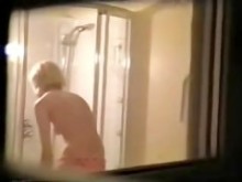 Escenas de ducha de una rubia espiada a través de la ventana