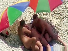 Trío en playa nudista