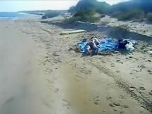 Pervertido en la playa pública se masturba en el culo de una chica nudista