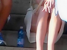 Mira debajo de la falda de una mujer que está sentada en las escaleras.