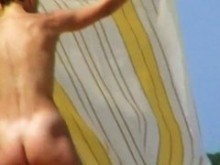 Madrastra completamente desnuda tomando el sol en la playa del río