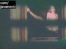 Mujer rubia espía en la ventana