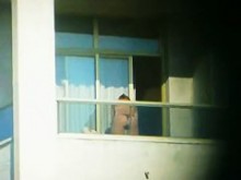 Morena sexy en topless filmada desde una ventana