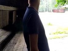 Chico pelirrojo jugando con una polla afuera bajo la lluvia mientras la gente pasa